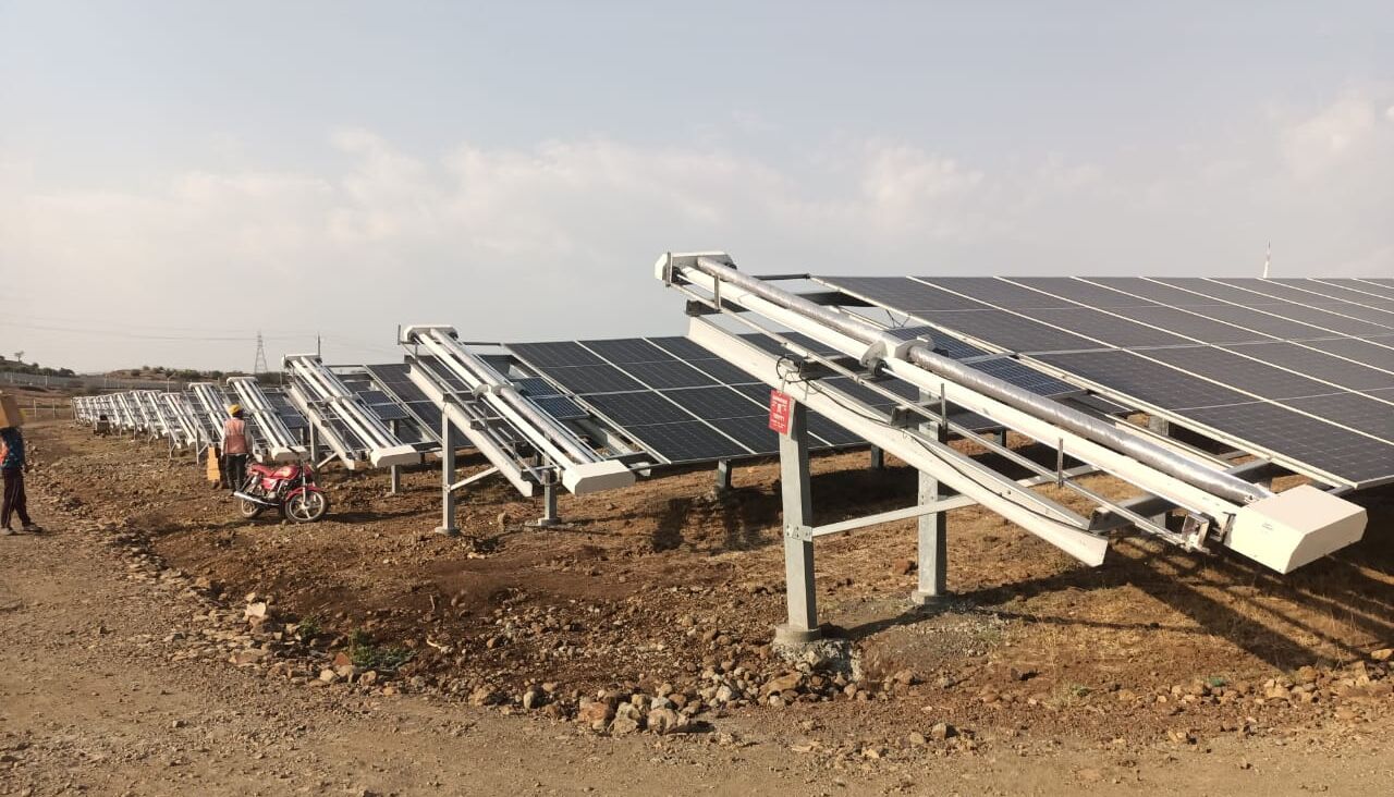 Wide-angle view of the 70 MW Banda Solar Project in India, highlighting tracker rows and site layout for optimal solar panel cleaning system deployment.